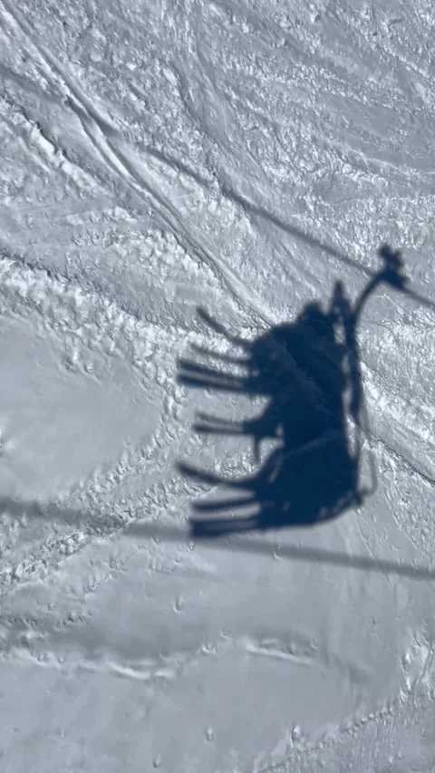 Shadow of skiers going up in a ski lift in a ski resort in French alps. Stock Footage 336927659