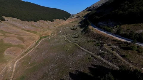 Shadow slowly moving across mountain valley road Video stock 283314561