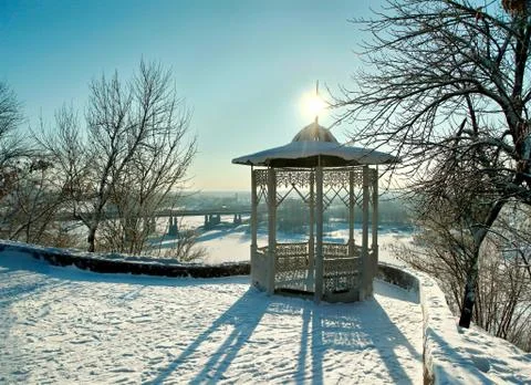 The shadow of the snow-covered gazebo in winter park Stock Photos