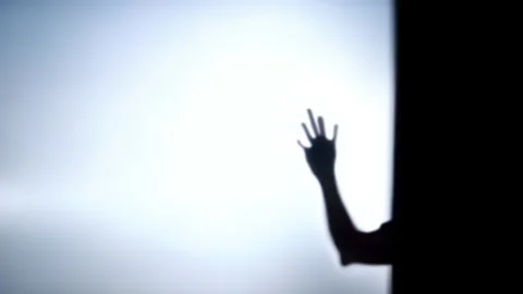 Shadow of spooky hand behind the frosted glass Stock Footage 252631664