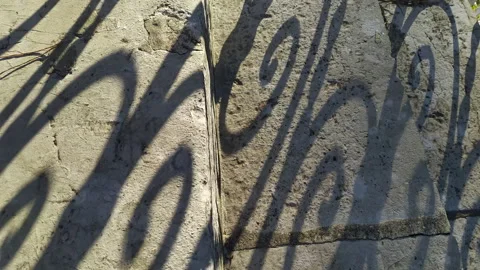 Shadow on stone stairs made of slabs cast by the curved pattern of wrought iron Stock Footage 233458567