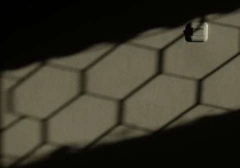 Shadow of the sun shining on the wall of the house during the golden hour Stock Photos