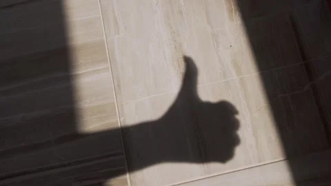 Shadow of Thumbs Up on Tiled Floor Stock Footage 317563543