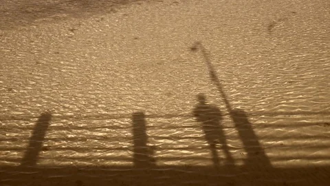 The shadow of two people on the bridge from the water on a sunny day. Stock Footage 121150845