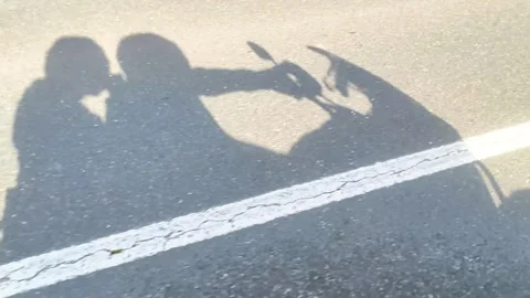 Shadow of two people riding a motorcycle on a sunny road Stock Footage 340533272
