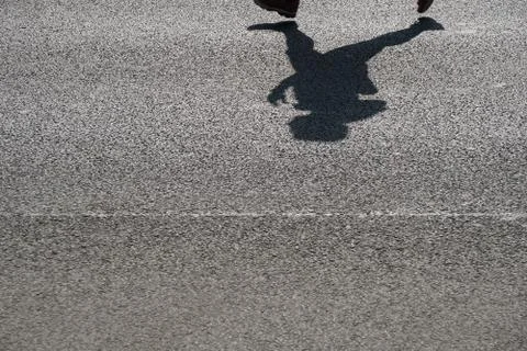 Shadow of an unrecognizable runner on asphalt Stock Photos