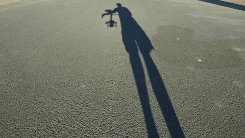 Shadow View of Person Walking with Camera Gimble System Stock Footage 80833876