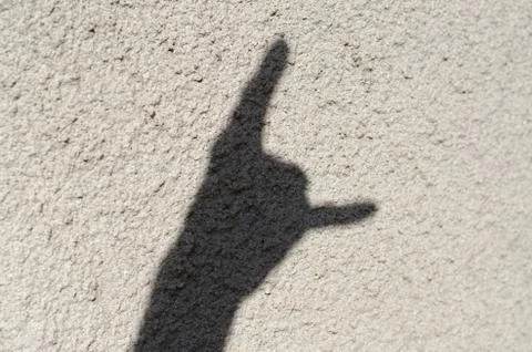 The shadow on the wall is a gesture of punks Stock Photos