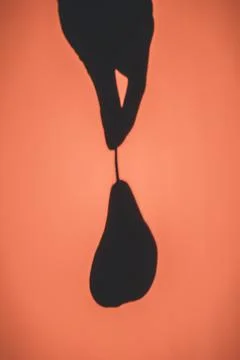 Shadow on the wall from a hanging pear. Background Stock Photos