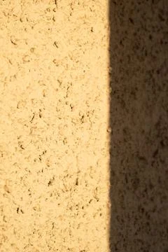 A shadow on the wall in the rays of the setting sun. Stock Photos