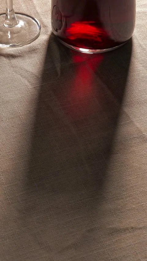 Shadow of wine bottle and glass on linen tablecloth Stock Footage 331774293