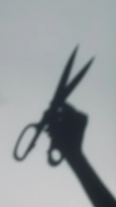 The shadow of a woman's hand holding sewing scissors Stock Footage 306618678