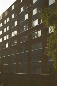 Shadowed brick facade of apartment building, tranquil twilight scene Stock Photos