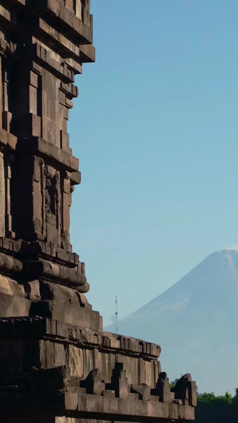 Shadowed Prambanan Temple architecture frames distant Mount Merapi beneath .. Stock Footage 341546398
