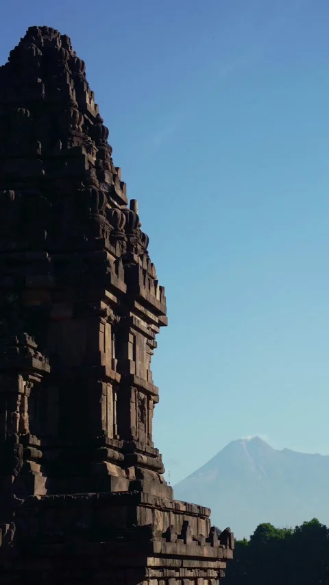 Shadowed Prambanan Temple tower forms a dramatic silhouette beside distant .. Stock Footage 341544931