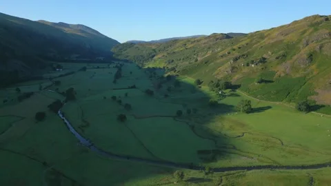 Shadowed valley with patchwork fields and winding stream on sunny summer Stock-Footage 248498412