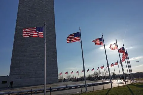 Shadowed Washington Monument frames American flag aglow Foto stock