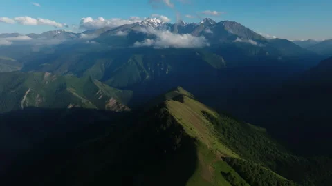 Shadows and sun highlight the rolling mountainous landscape. Expansive Mountain Stock Footage 265032437