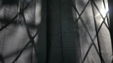 Shadows of the barred window fall on the window shades.  Timelapse. Stock Footage 141879941