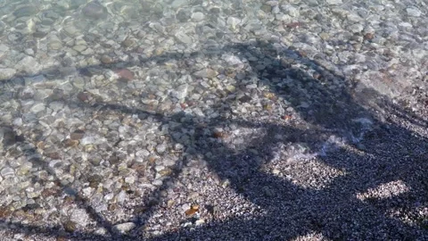 Shadows dance over the crystal-clear waters of Lake Garda in Sirmione Stock Footage 301885941