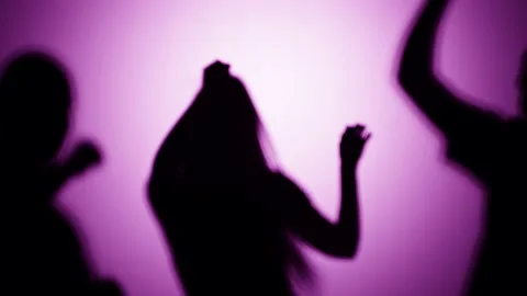 Shadows of dancing people on pink background. Silhouette of men and woman having Stock Footage 170735785