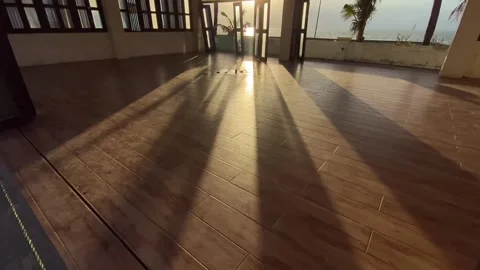 Shadows flood an empty seaside function hall at the beach during sunset. Video stock 260973567