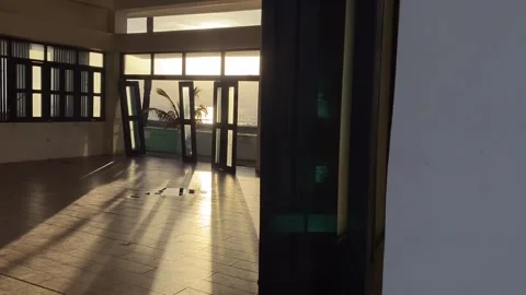 Shadows flood an empty seaside function hall at the beach during sunset. Video stock 260973584