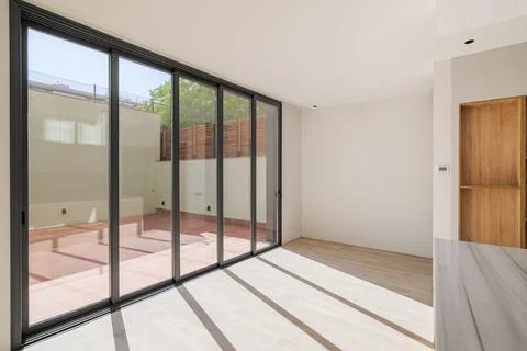 Shadows on the floor from sunlight through big windows. New room with wooden 스톡 사진