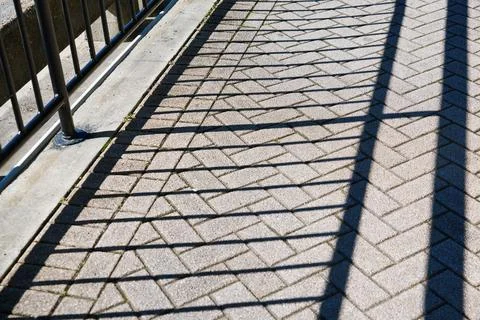 Shadows on the ground of a cobblestone footpath Stock Photos