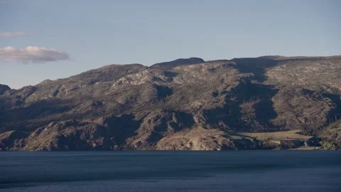 Shadows growing long on a mountain across the lake Stock Footage 282112198