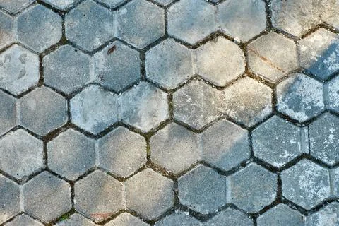 Shadows on hexagonal paving tiles. Textured concrete pavement blocks. Old s.. Stock Photos