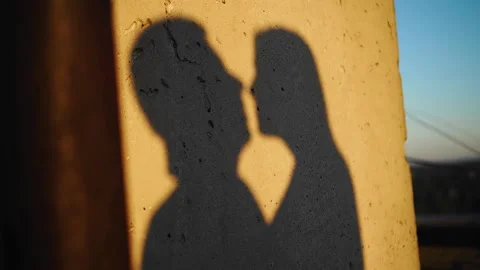 Shadows from the kiss of two lovers on the wall at sunset Stock Footage 307224726