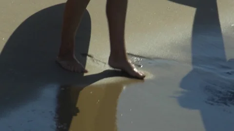 Shadows of longboard surfboards and their fins appear in the sand. Stock Footage