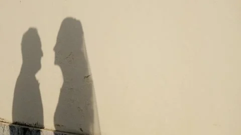 Shadows of lovers against the wall at sunset. Silhouette of young couple kissing Stock Footage 154115904