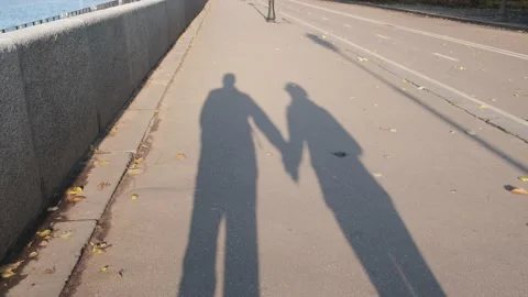 The shadows of lovers on the asphalt in motion take hands. Vidéo 142998830