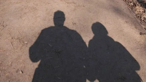 The shadows of lovers on the asphalt in motion take hands. Stock Footage 155205691