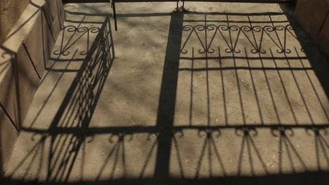 Shadows of man and the grating of the gate. A man comes in, comes out Stock-Footage 120980691