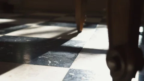 Shadows move across a tile interior floor, pans up to a centrepiece on a Stock Footage 101962171