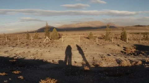 Shadows of people on background dry area and far mountains sunset Stock Footage 77877581