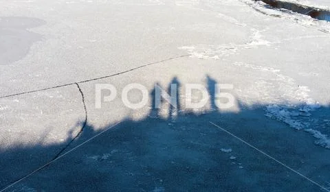 Shadows of people standing in the winter on a high bank of the river, fall on Stock Photos