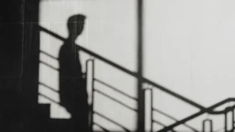 A shadows of a person going up and down the stairs while playing with a Mobile d Stock Footage 140184591