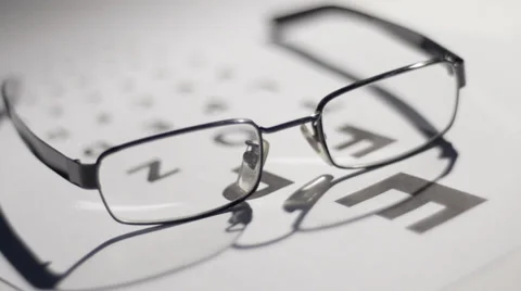 Shadows playing across glasses and eyetest chart Stock Footage 33895857