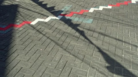 Shadows of red and white festive flags cast on textured paving blocks, symb.. Stock-Footage 344356003