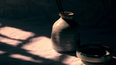 Shadows of a swaying leaf cast on a ceramic incense holder Video stock 205505206