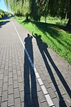 Shadows of two people on the sidewalk. Stock Photos