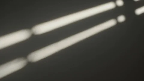 Shadows on the wall of an electric window shutter being opened in room Video stock 107656518