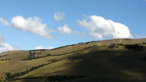 Shadows of white clouds running on green hills in wild nature landscape. Blue Stock-Footage 241286524