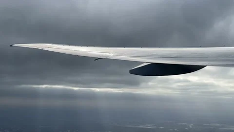 Shadows on wing of plane from clouds. View from plane to clouds and sunbeams. Video stock 163904433