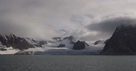 Shadowy Glacier flows into ocean from passing ship Stock Footage 61521687