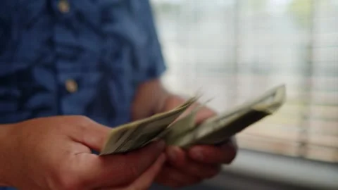 Shady Wealth Scene With Man Counting Money Near Window In Home Setting Video stock 312524941